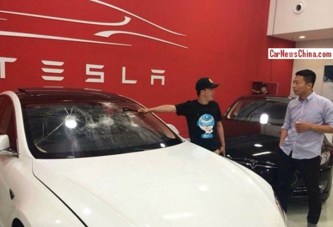Ông Yu cầm chiếc cờ lê để đập vỡ kính chiếc Tesla Model S mới nhận.