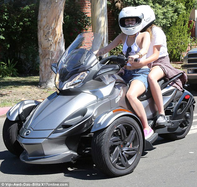 Miley Cyrus đưa em gái đi chơi bằng xe ba bánh Can-Am Spyder màu thuốc súng.