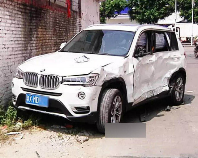 Chiếc BMW màu trắng của người vợ bị đâm nát sườn xe.