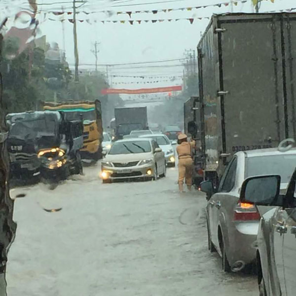 Lực lượng CSGT Quảng Ninh đội mưa để điều tiết giao thông và đẩy xe cho người dân. Ảnh: Otofun