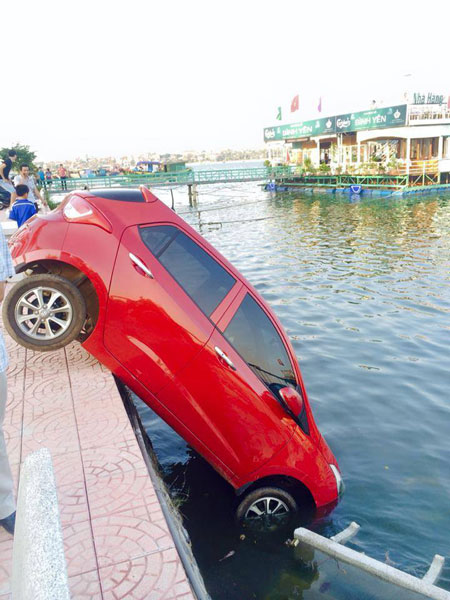 Chiếc Hyundai Grand i10 màu đỏ cắm đầu xuống hồ (Ảnh: Tuan Anh Nguyen/Otofun).