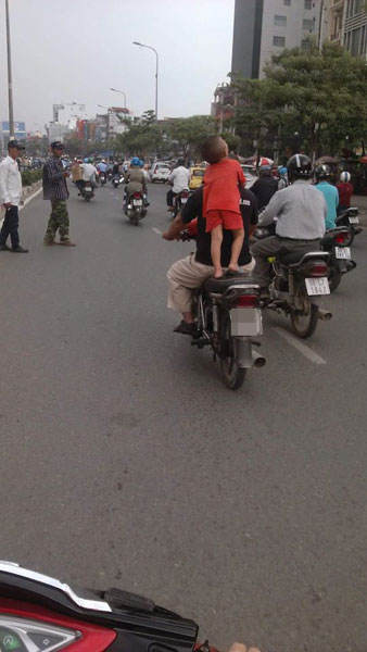 Hành động chở trẻ nhỏ nguy hiểm bằng xe máy của người đàn ông tại Sài Gòn
