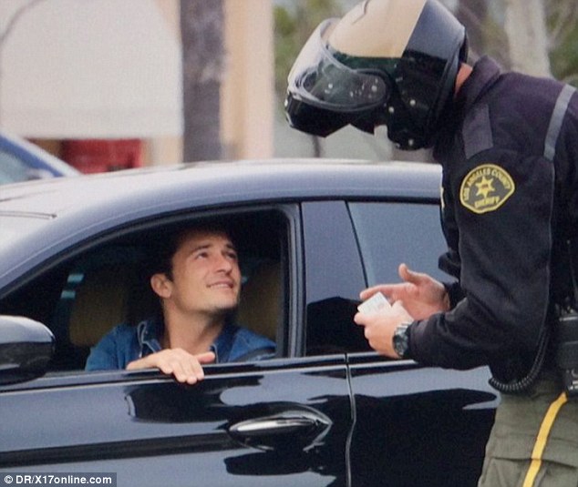 Orlando Bloom cười nói với người cảnh sát để lấy lòng.