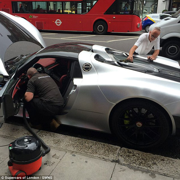 Hai người đàn ông chăm sóc chiếc siêu xe, từ rửa đến hút bụi nội thất.