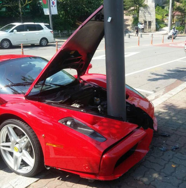 Cột điện nằm kẹt giữa đầu xe của chiếc Ferrari Enzo màu đỏ.