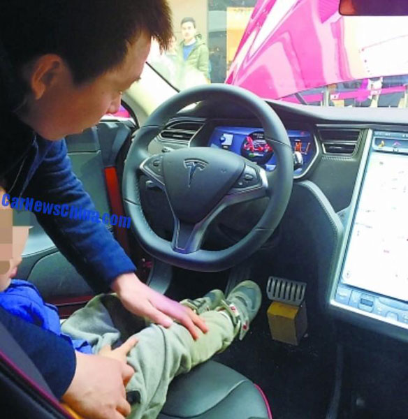 Một ông bố cho con ngồi vào ghế lái của chiếc Tesla Model S sau vụ tai nạn.