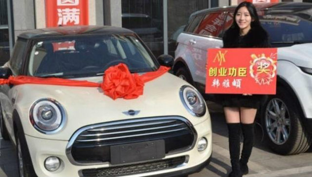 Một nhân viên đứng bên cạnh chiếc xe Mini được thưởng.