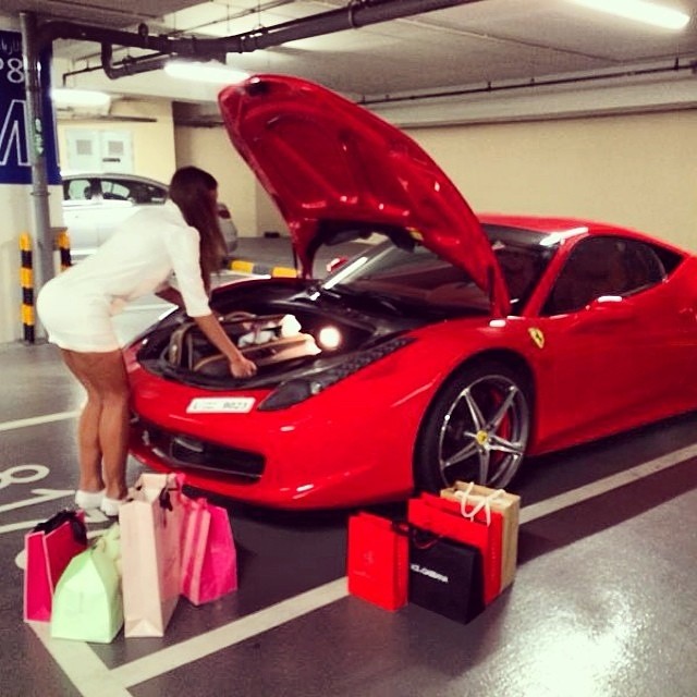 Một cô nàng lấy đồ từ cốp bên dưới nắp capô của chiếc siêu xe Ferrari 458 Italia sau chuyến mua sắm vung tay.