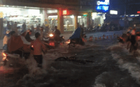 
Nam thanh niên chạy thật nhanh theo chiếc xe bị trôi giữa dòng nước ngập.
