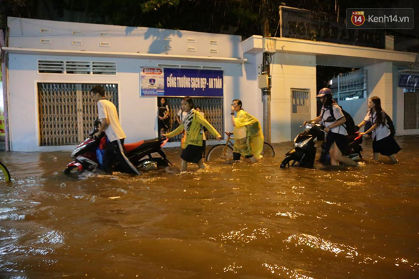 
Các bạn học sinh, sinh viên khó khăn di chuyển khi cơn mưa nặng hạt kéo tới. Ảnh: Toàn Nguyễn.
