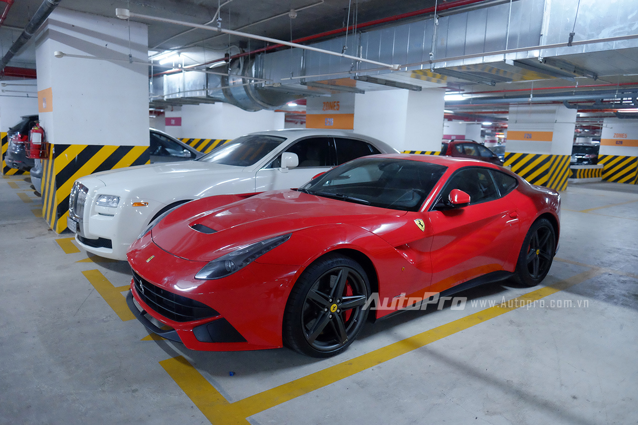 
Chiếc xe Ferrari F12 Berlinetta đỏ đỗ cạnh chiếc Rolls-Royce Ghost màu trắng tại hầm gửi xe một khu chung cư tại Hà Nội.
