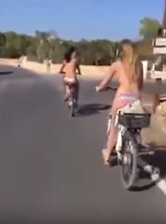 
Hai cô gái chỉ mặc quần mà quên áo và đạp xe trên đường giữa ban ngày. Ảnh cắt từ video
