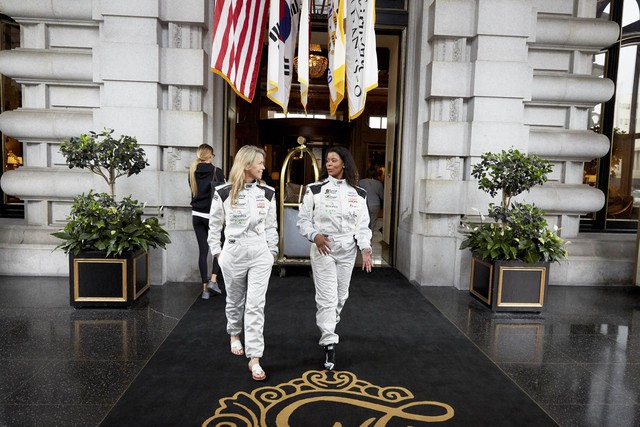 
Trong hình là Christine Sloss và Chanterria McGilbra (bên phải) đang rời khỏi khách sạn Fairmont để chuẩn bị cuộc đua. Họ đều mặc những bộ trang phục tiêu chuẩn cho những chiếc xe đua.
