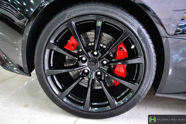 
Siêu xe Aston Martin Vanquish mui trần sở hữu bộ la-zăng hợp kim thể thao 10 chấu đơn được sơn đen bóng tông xuyệt tông với ngoại thất, điểm nhấn là cùm phanh màu đỏ nổi bật.
