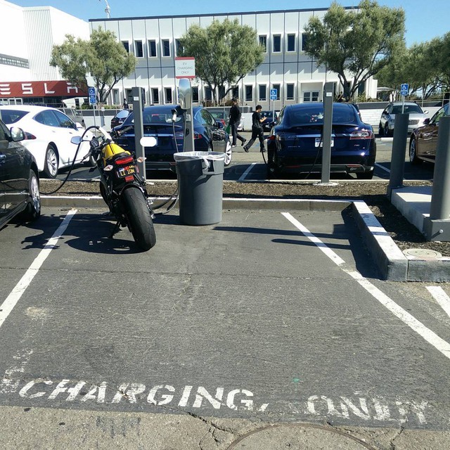 
Một nhân viên của hãng Tesla thể hiện tình yêu môi trường bằng cách lái mô tô điện đi làm. Sau đó, người này đưa chiếc mô tô vào chỗ dành riêng cho ô tô điện và cắm sạc. Thế là một chiếc ô tô chạy điện mất chỗ đậu ngày hôm đó.
