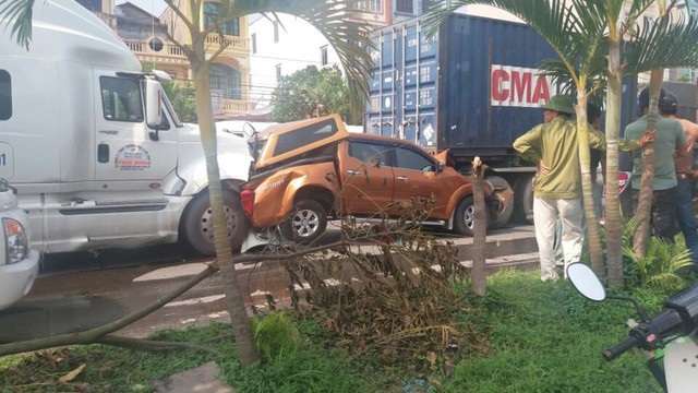 
Chiếc Nissan Navara bị kẹp giữa 2 xe container.
