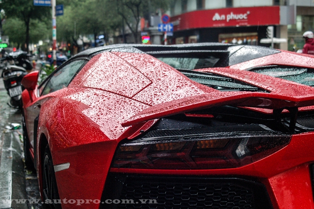 
Những giọt nước mưa đọng lại trên bộ áo đỏ rực của siêu xe Lamborghini Aventador mui trần càng khiến người ngắm như bị thôi miên.
