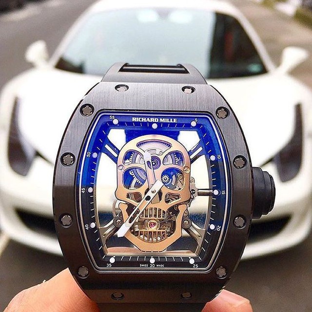 
Lấy cảm hứng từ sự vĩnh cửu, RM052 Skull với thiết kế mặt đầu lâu được xem là một trong những thiết kế được ưa chuộng nhất của Richard Mille. Phần vỏ của RM 052 được chế tác từ ceramic, trong khi đó phần đầu lâu nổi bật giữa mặt đồng hồ được chế tác từ vàng, cùng cơ chế Tourbillon khiến chiếc đồng hồ này có giá lên đến 500,000 USD. Trong hình là chiếc đồng hồ Richard Mille RM052 Skull nổi bật bên chú ngựa Ferrari 458.
