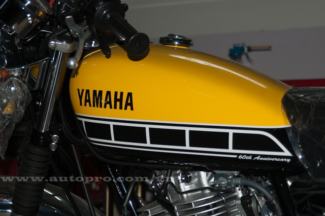 
Bình xăng trên chiếc Yamaha SR400 bản kỷ niệm được phủ màu vàng nổi bật, điểm nhấn là các chi tiết khoác màu đen và trắng cùng dòng chữ 60th Anniversary xuất hiện góc dưới cùng.
