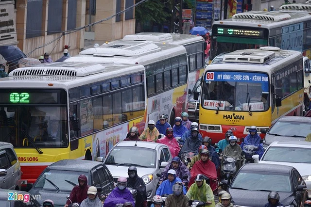  Xe buýt ùn ùn nối đuôi nhau. Người đi xe máy chôn chân trong mưa nhích từng bước tại đường Nguyễn Trãi.