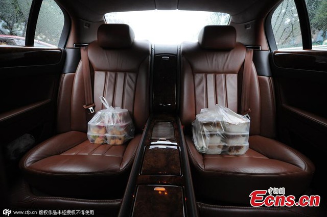 Các túi đồ ăn vặt được để trên hàng ghế sau của một chiếc Porsche do anh Zhang cầm lái.
