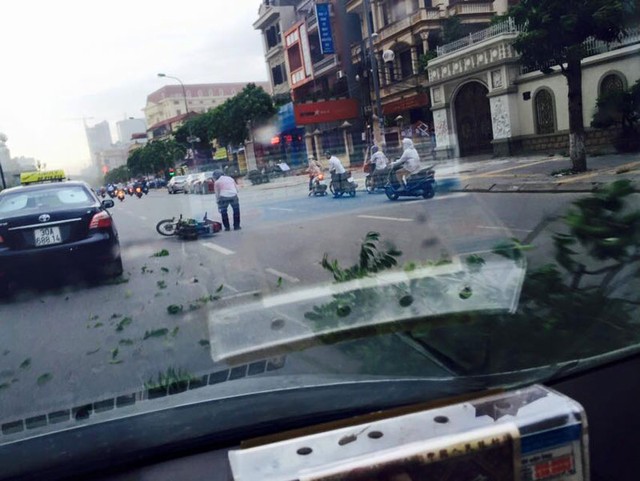 Cành cây bay xuống đường khiến một người đi xe máy gặp tai nạn. Ảnh: Tuan Thanh/Otofun