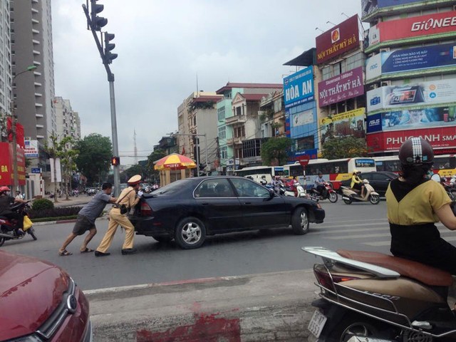 Hình ảnh CSGT đẩy xe ô tô &quot;chết máy&quot; cùng người dân tại Hà Nội.
