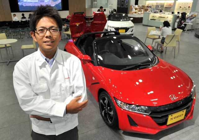 Ryo Mukumoto đứng bên cạnh một chiếc Honda S660 màu đỏ rực.
