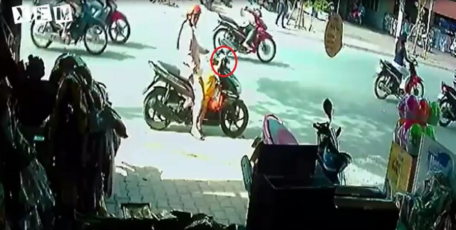 Cậu bé vịn vào tay lái bên phải của chiếc xe ga. Ảnh cắt từ video