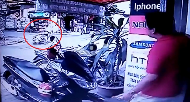 Chiếc xe ga lao sang bên kia đường, kéo theo cả người mẹ. Ảnh cắt từ video