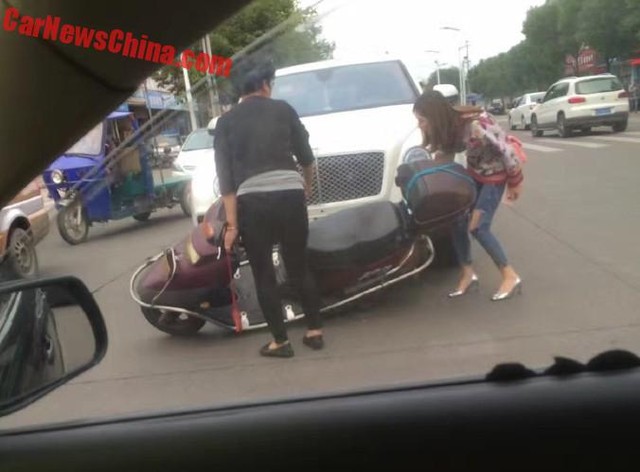 
Cô gái trẻ xuống xe và kiểm tra xem chiếc Bentley Bentayga có bị hỏng hay không.
