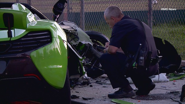 
Một cảnh sát khám nghiệm hiện trường bên cạnh chiếc McLaren 650S Spider vỡ nát.
