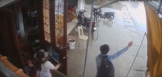 Nam thanh niên đứng dưới hiên nhà vẫy khách. Ảnh cắt từ video
