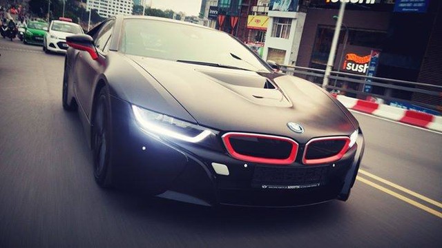 BMW i8 tại Hà Nội với ngoại thất đen nhám và đường viền lỗ mũi lưới tản nhiệt hay ốp gương trong màu đỏ nổi bật.
