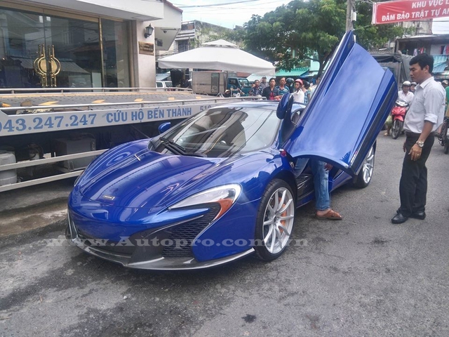 
Vài phút sau, McLaren 650S Spider cũng được đưa từ xe cứu hộ xuống mặt đường và được tài xe riêng của Minh Nhựa (áo trắng) lái vào garage.
