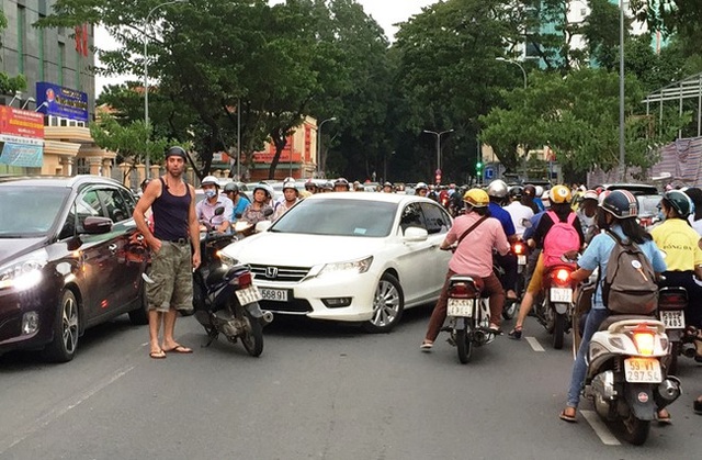 
Nam thanh niên dùng xe máy chặn trước đầu ô tô 4 chỗ trên đường Đinh Tiên Hoàng, quận 1. Ảnh: K.A.
