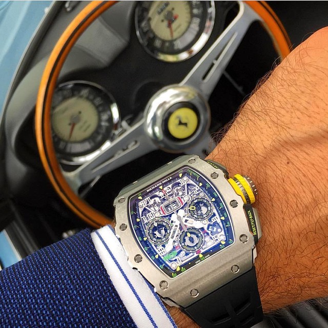 Một đại diện đến từ Richard Mille trong bài viết lần này, đó là chiếc đồng hồ RM 11-03 khoe bộ máy tourbillion đầy mê hoặc của mình bên trong buồng lái siêu xe Ferrari Spyder. RM 11-03 là một tổng thể gồm những chi tiết được truyền cảm hứng bởi những chiếc xe đua: núm crown làm bằng titanium cấp độ 5 mang dáng dấp của chiếc lốp và bánh xe công thức 1; nút bấm có các đường khía gợi nhớ tới bề mặt của những chiếc pedals và có phần vỏ bọc làm bằng vật liệu quen thuộc với công thức 1, đó là NTPT Carbon - vật liệu siêu bền, siêu cứng và siêu nhẹ đã trở thành một đặc trưng trong những thiết kế của Richard Mille.