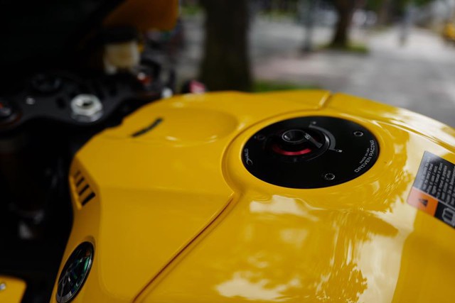 
Đối lập với bộ áo màu vàng rực của bình xăng là nắp đậy nhiên liệu màu đen kết hợp cùng đường viền màu đỏ của Driven Racing.
