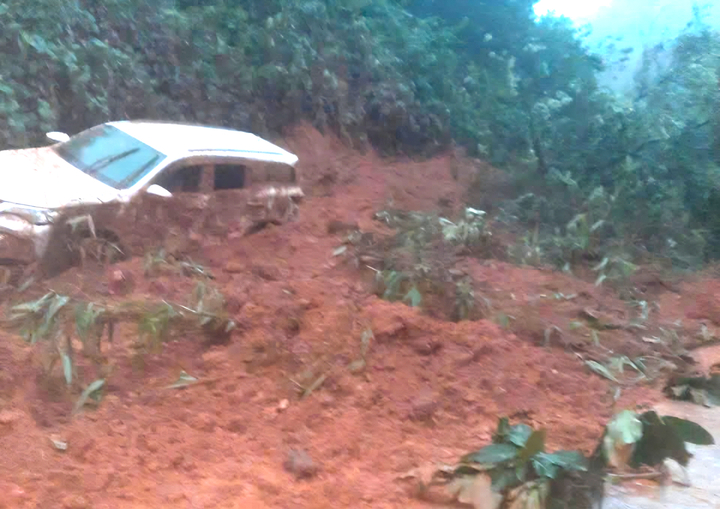 Ô tô 7 chỗ bị đất vùi lấp sau sạt lở, 2 người may mắn thoát chết- Ảnh 1.