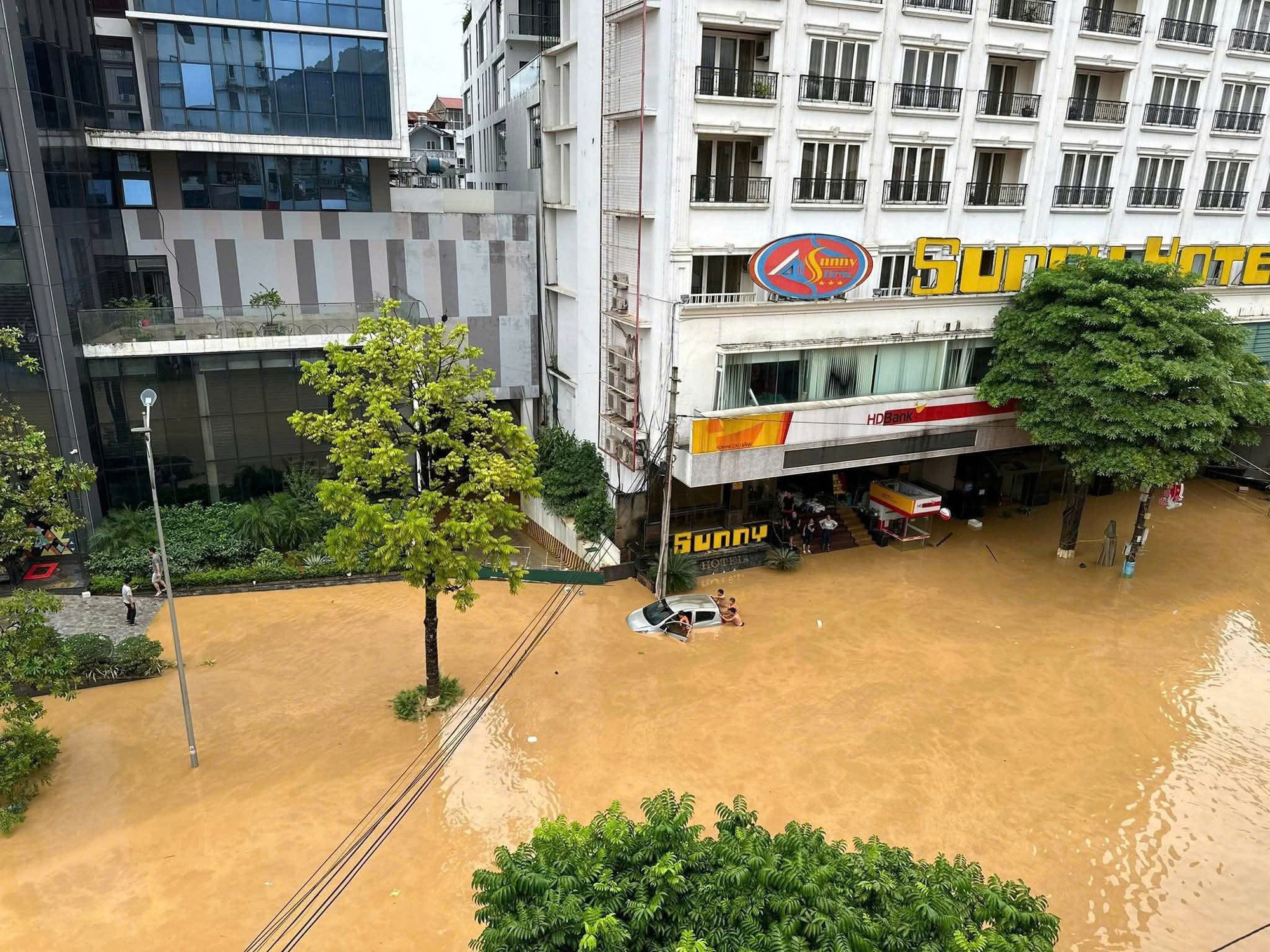 Ô tô bị dòng nước lũ cuốn, tài xế hoảng loạn không thể thoát ra ngoài: Clip giải cứu căng thẳng- Ảnh 1.