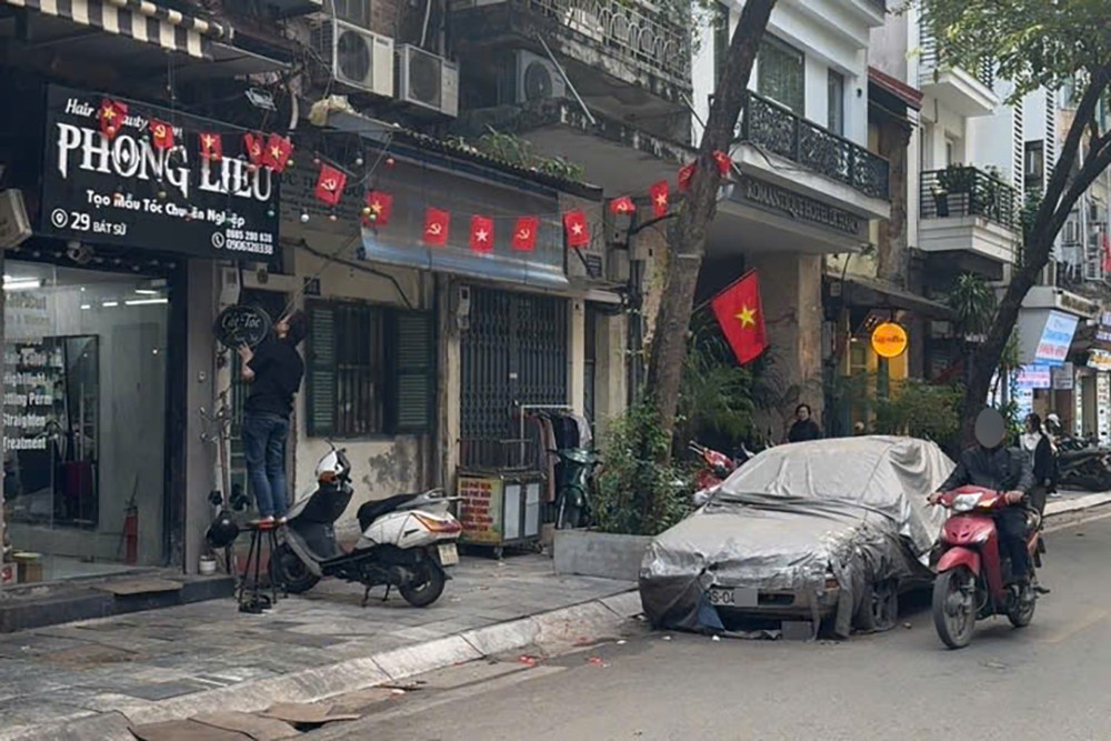 Cẩu, kéo chiếc ô tô phủ bạt, bị 'bỏ quên' nhiều năm trên phố Bát Sứ- Ảnh 1.