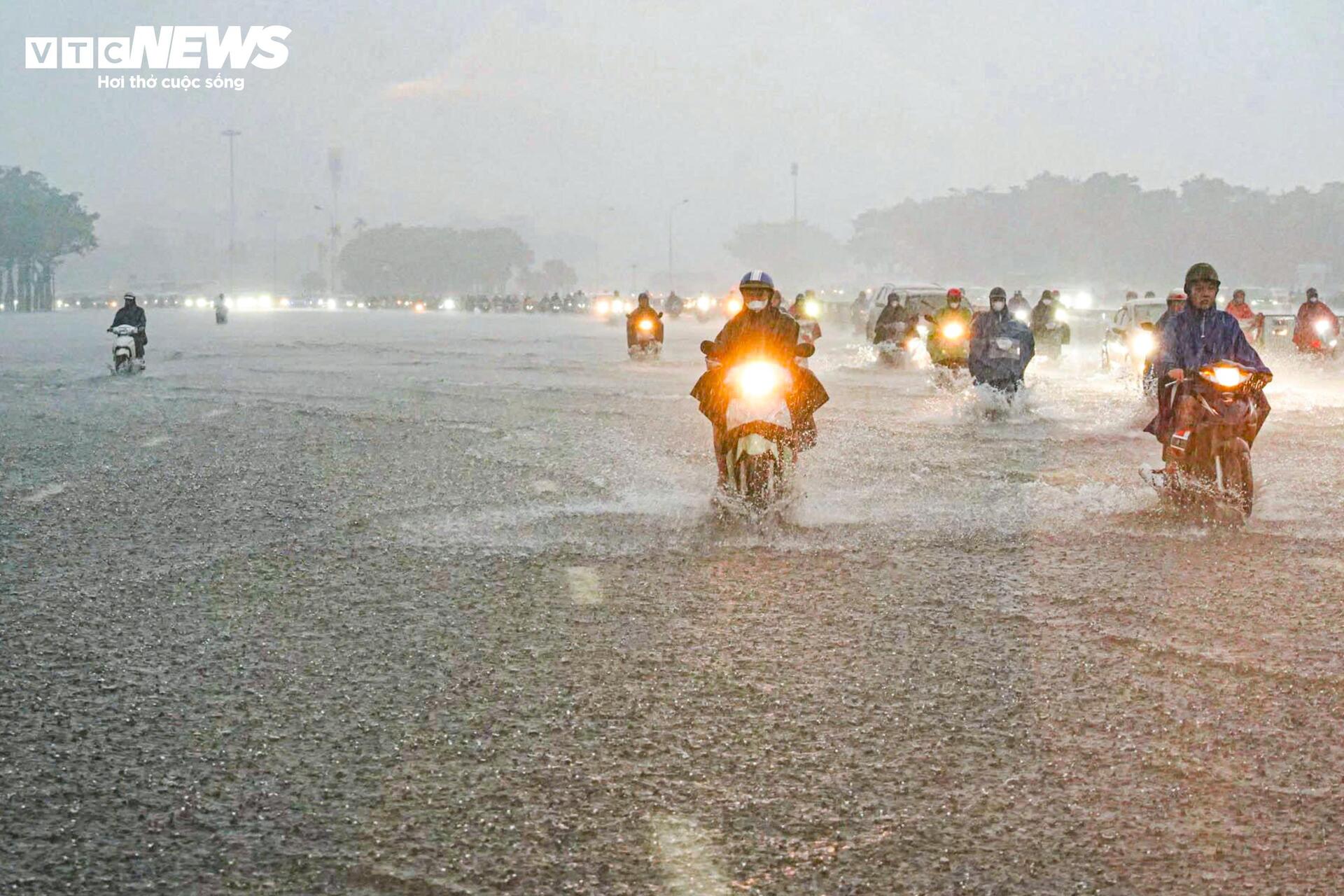 Loạt tuyến phố Hà Nội ngập nặng, người dân bì bõm dắt xe dưới mưa lớn- Ảnh 1.