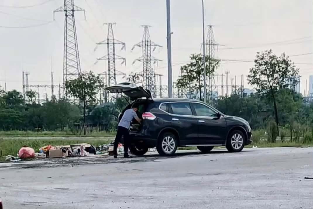 Danh tính người đàn ông đi ô tô vứt rác giữa đường ở Nghệ An, công an mời làm việc - Ảnh 1.