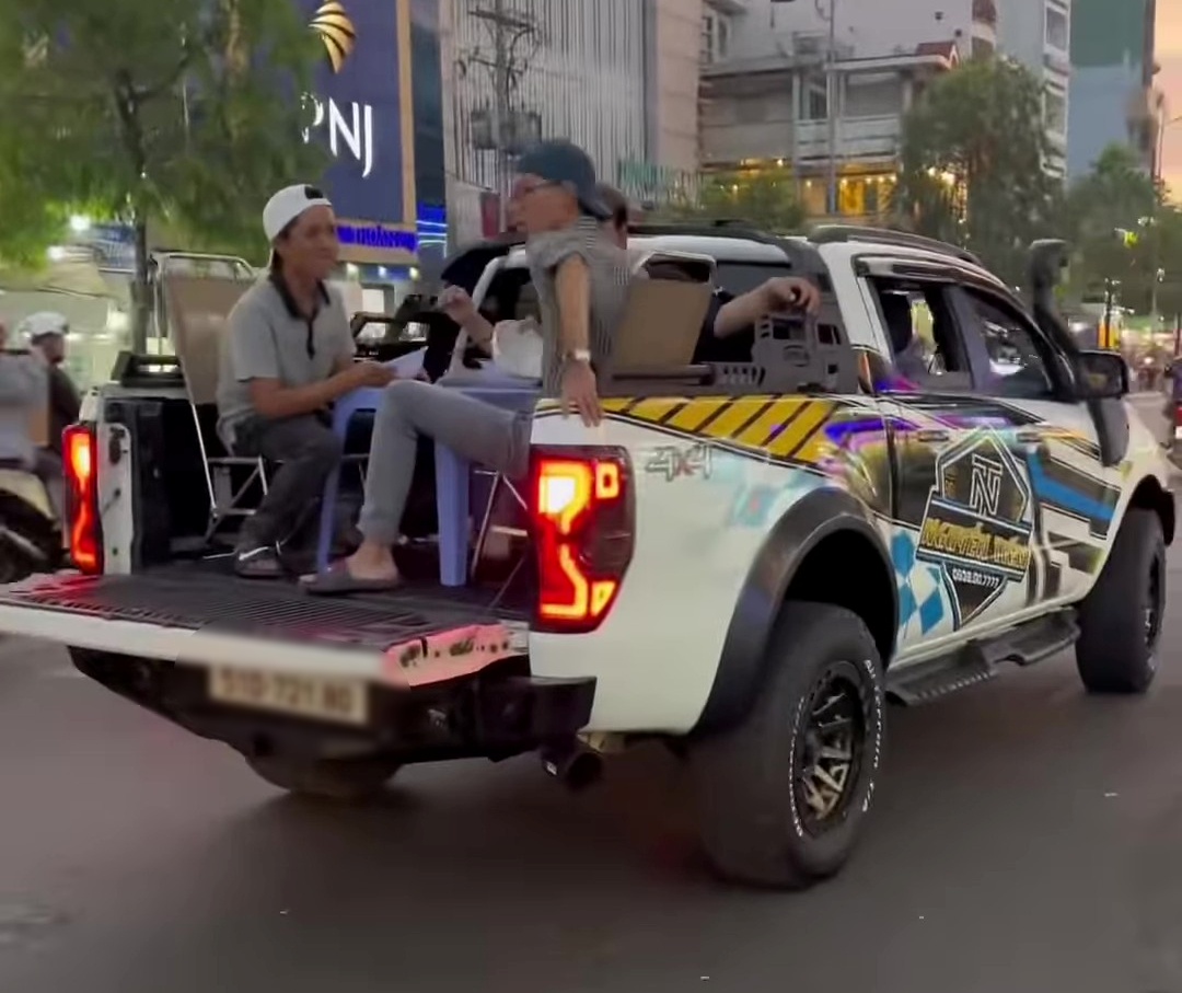 Nh&oacute;m thanh ni&ecirc;n k&ecirc; b&agrave;n ghế, ngồi ăn tr&ecirc;n th&ugrave;ng xe b&aacute;n tải đang chạy ở TP.HCM- Ảnh 1.