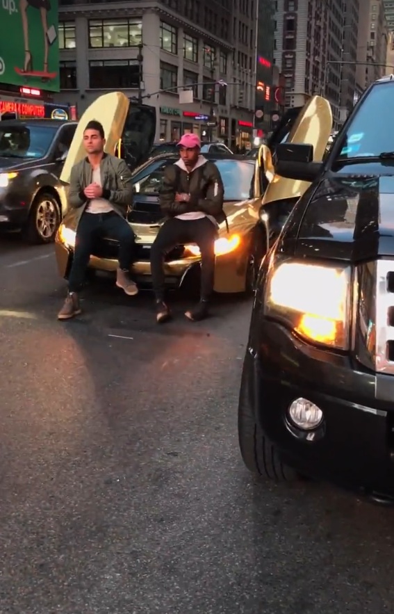 
2 thiếu gia ngồi trên nắp capô của BMW i8 tung cánh để chụp ảnh. Ảnh cắt từ video
