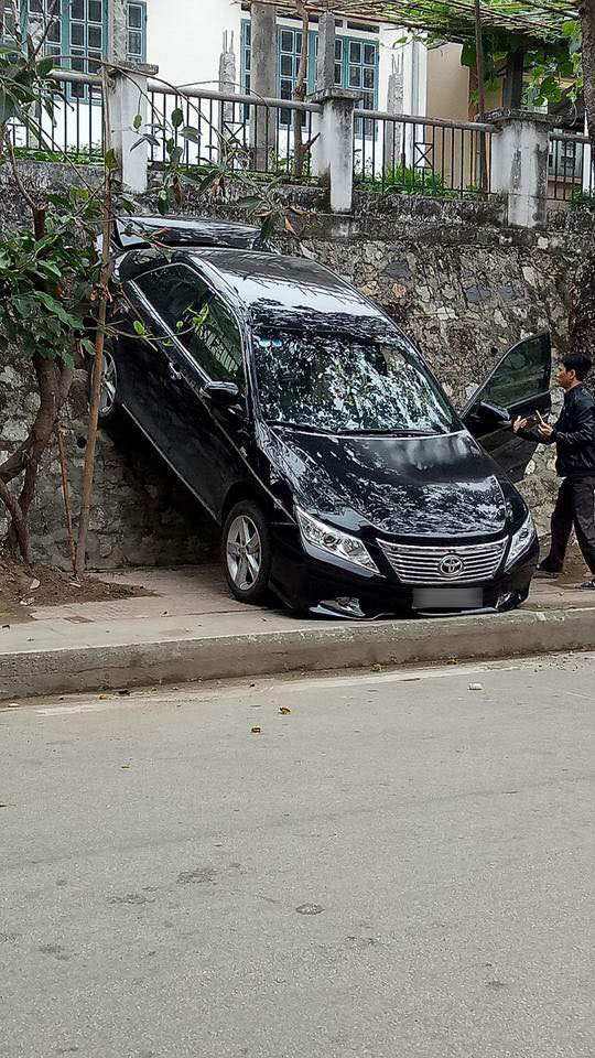 Lào Cai: Lùi quá đà, Toyota Camry gác đuôi lên bức tường - Ảnh 1. Lào Cai: Lùi quá đà, Toyota Camry gác đuôi lên bức tường - Ảnh 1.