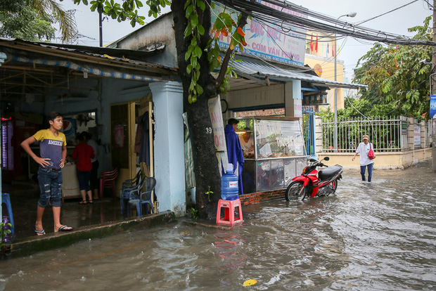 Học sinh ở Sài Gòn bì bõm lội nước sau giờ tan học do mưa lớn kéo dài từ sáng đến trưa - Ảnh 1.