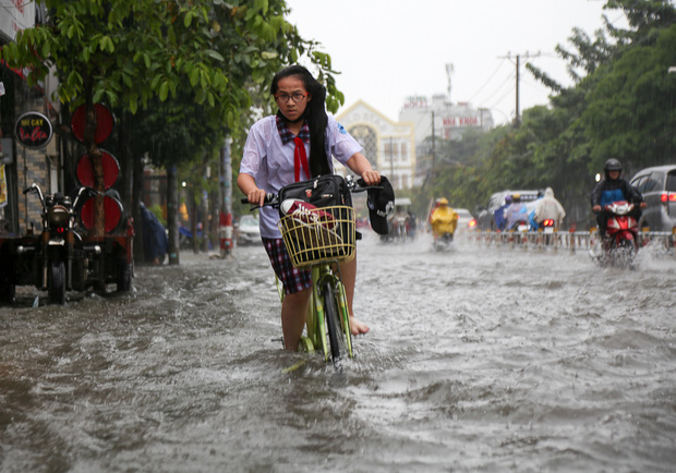 Học sinh ở Sài Gòn bì bõm lội nước sau giờ tan học do mưa lớn kéo dài từ sáng đến trưa - Ảnh 2.