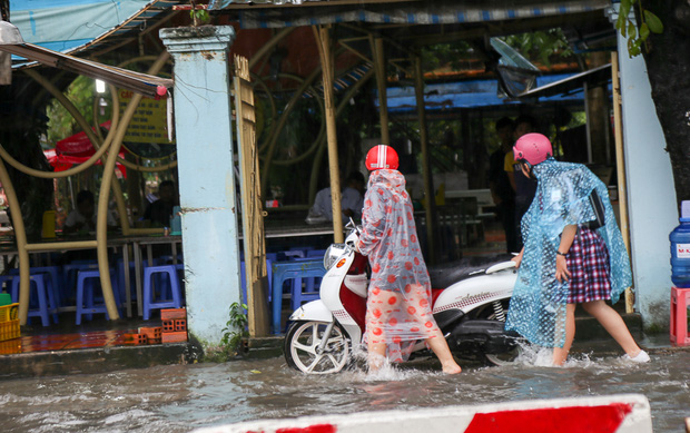 Học sinh ở Sài Gòn bì bõm lội nước sau giờ tan học do mưa lớn kéo dài từ sáng đến trưa - Ảnh 3.