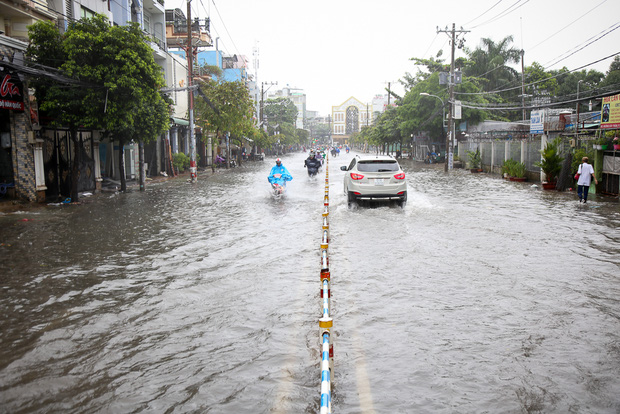 Học sinh ở Sài Gòn bì bõm lội nước sau giờ tan học do mưa lớn kéo dài từ sáng đến trưa - Ảnh 4.